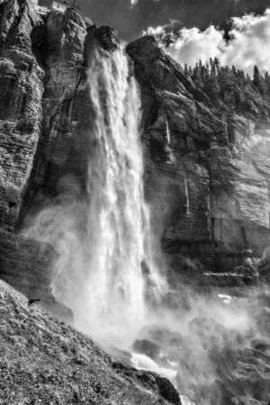 Mountain Roar. Black and white photograph of roaring misting Bridal Veil Falls in Telluride Colorado under afternoon sun. Black and white photograph of roaring misting Bridal Veil Falls in Telluride Colorado under afternoon sun